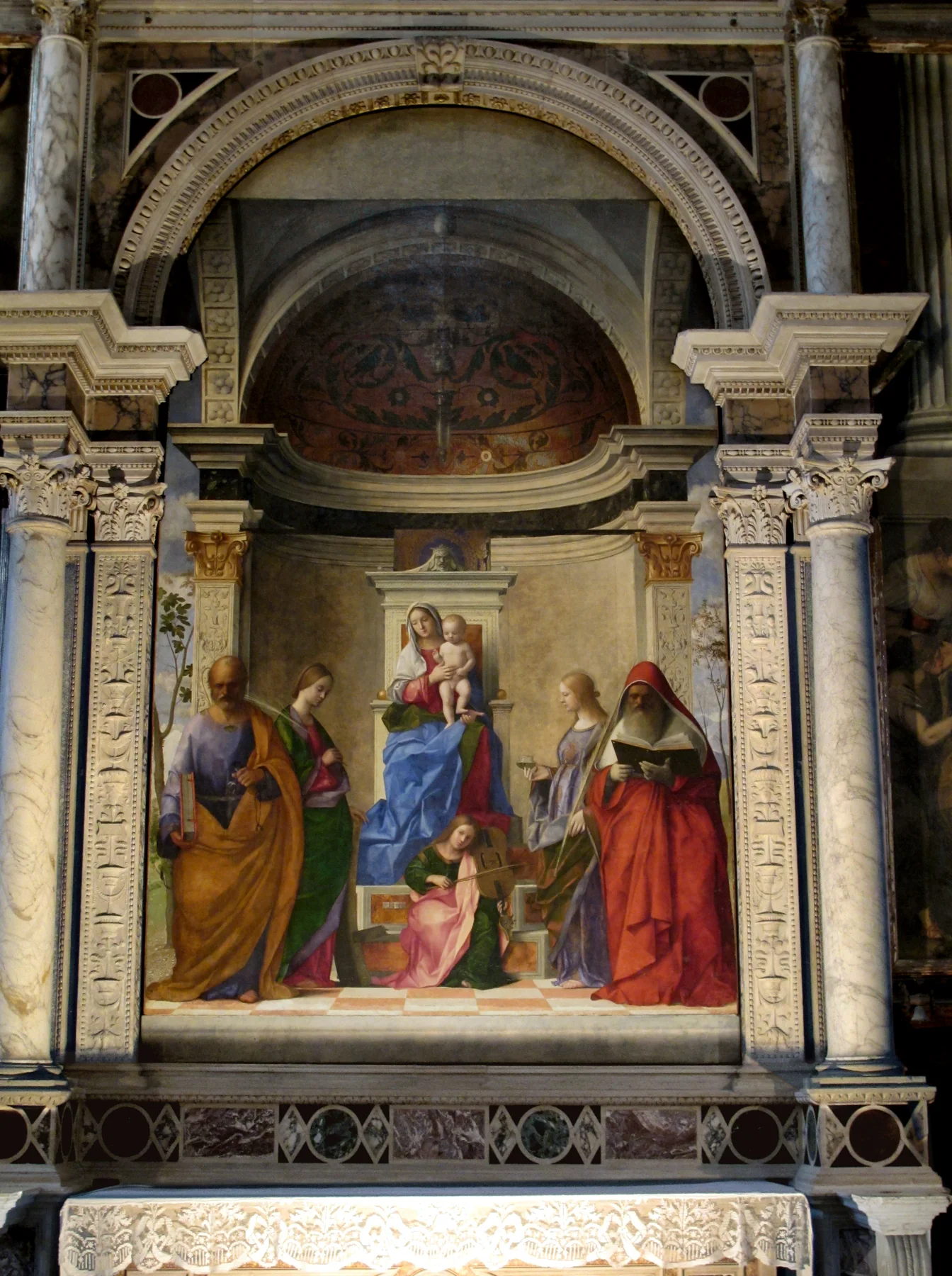 Giovanni Bellini'nin San Zaccaria Sunak Resmi mermer kilise sunağında; boyalı mimari içinde Meryem ile çocuk azizlerle çevrili.