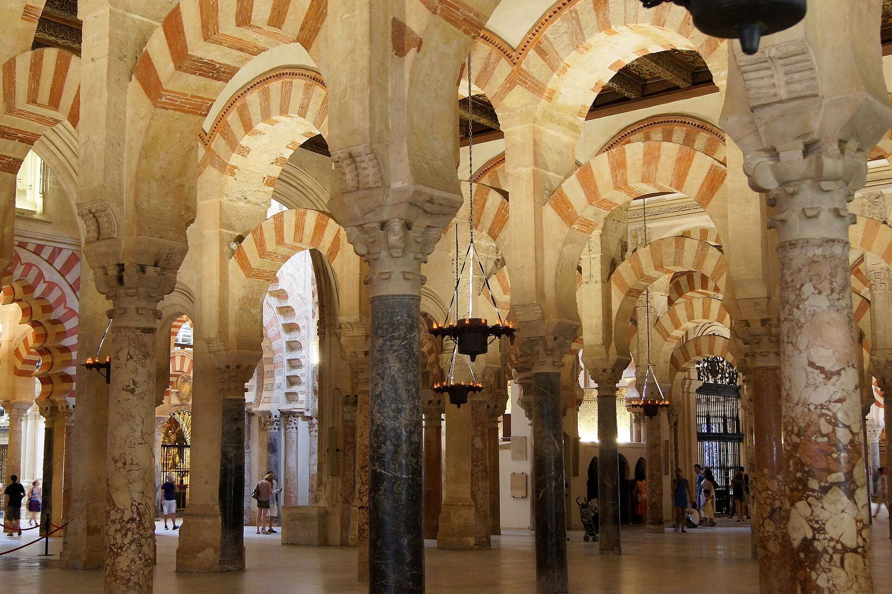 Kurtuba Camii-Katedrali içinde yeniden kullanılan taş ve mermer sütun sıraları üst üste kırmızı-krem kemerleri taşıyor; aralarında sonraki mimari katmanlar görülüyor.