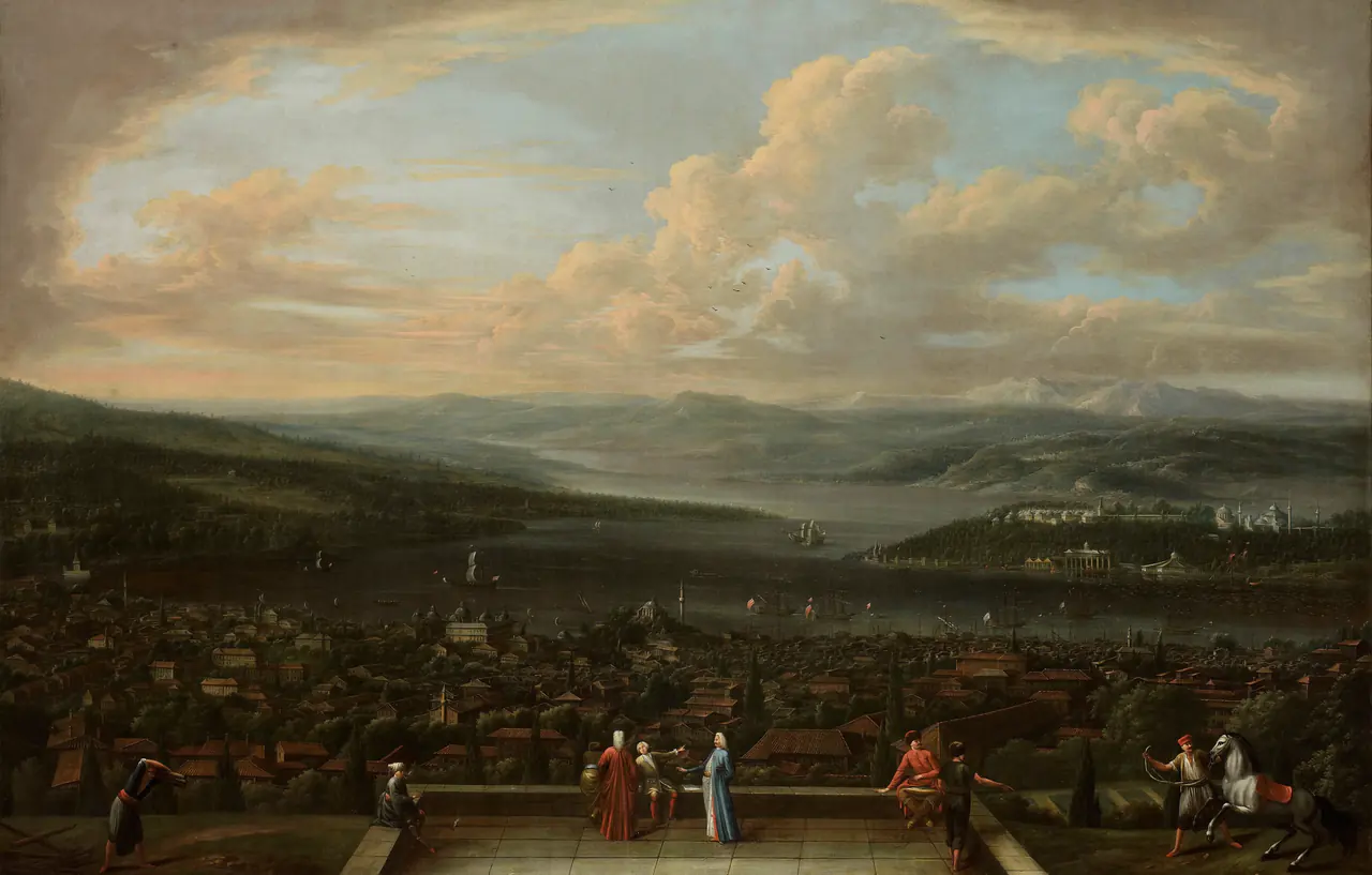 Small figures stand on a terrace above dense rooftops, ships and curving waterways, under a large sky filled with pale clouds.
