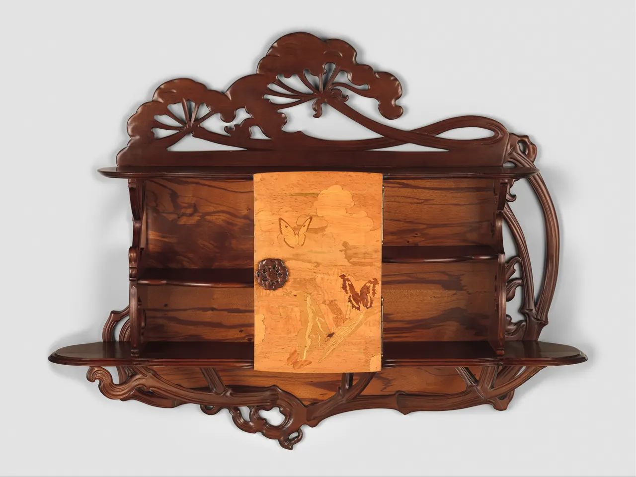 Carved cow-parsley flower heads, curving stems and a butterfly-decorated door shape Gallé’s wooden cabinet