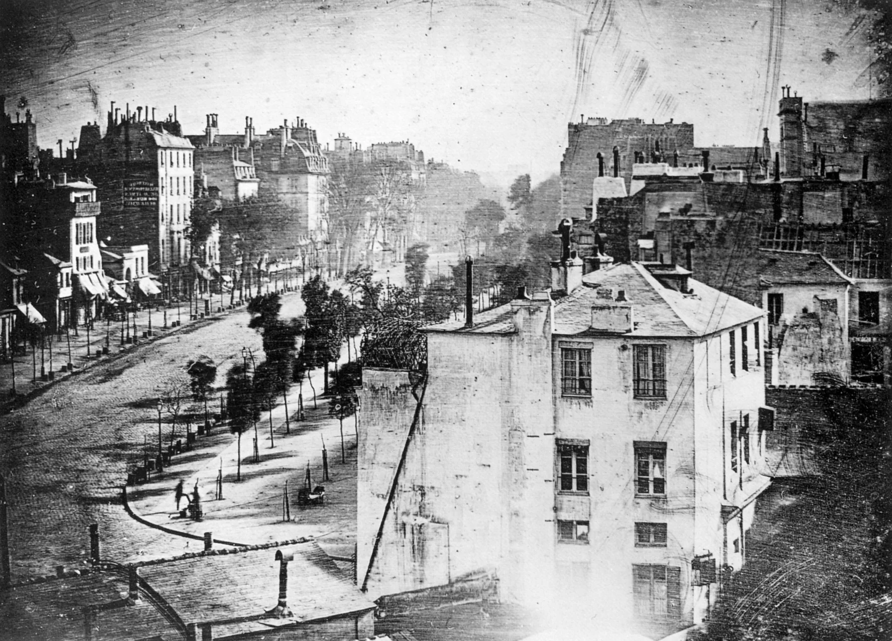 Paris çatıları ile Boulevard du Temple'ın yüksekten görünümü, sol alt sokak köşesindeki iki küçük koyu figür dışında neredeyse boş görünüyor.