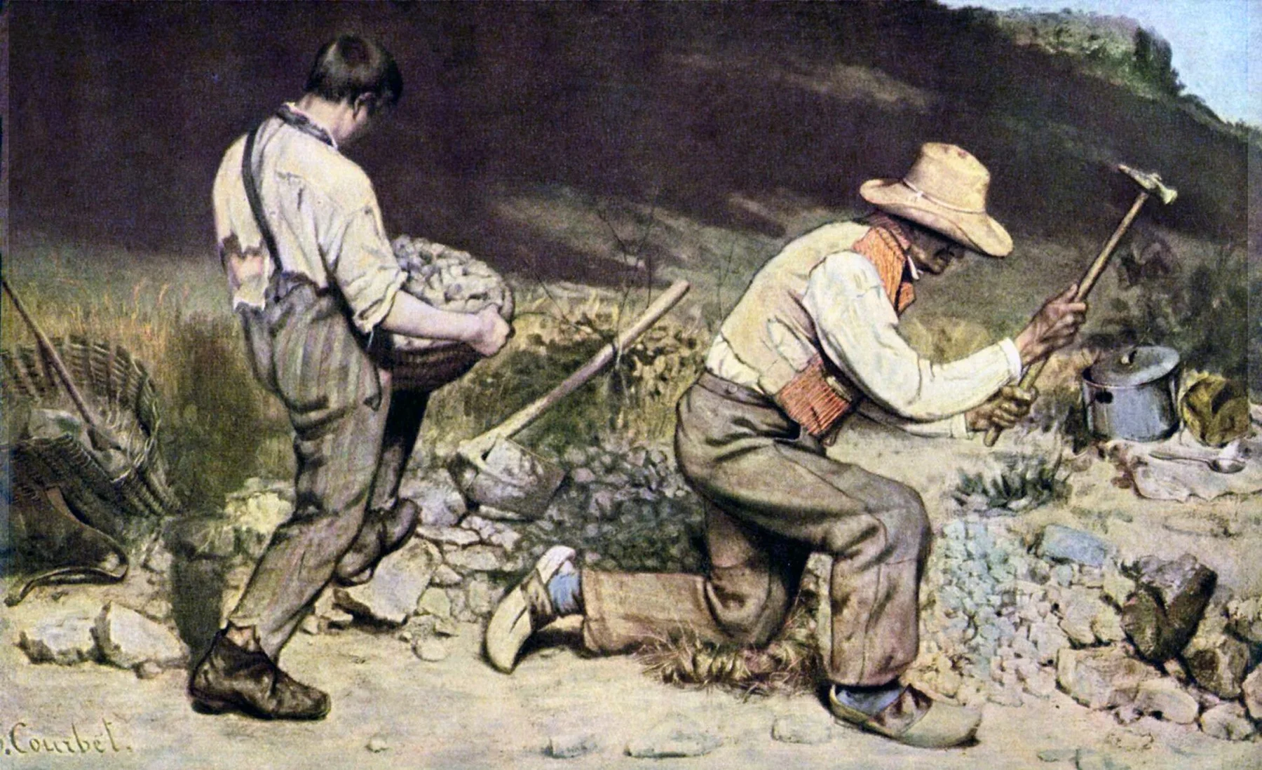 Yaşlı bir adam çekiçle taş kırmak için diz çökerken genç işçi alçak, koyu yamacın yanında kırık kaya dolu ağır sepeti taşıyor.