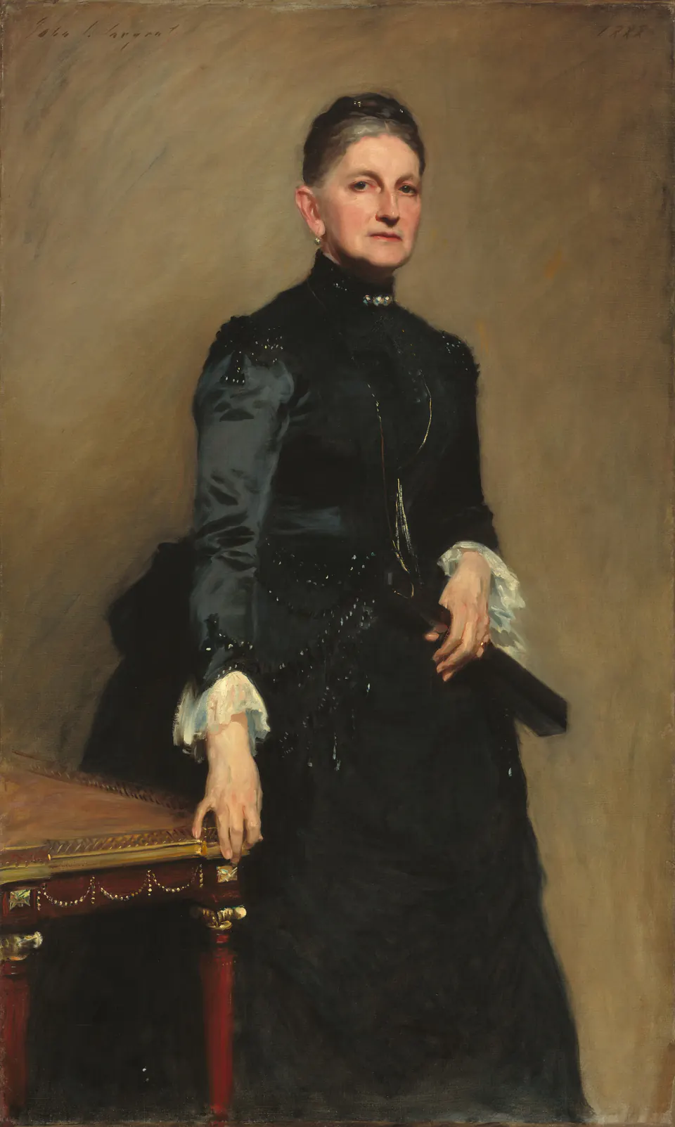 Eleanora Iselin in a high-collared black dress gripping the corner of a red table