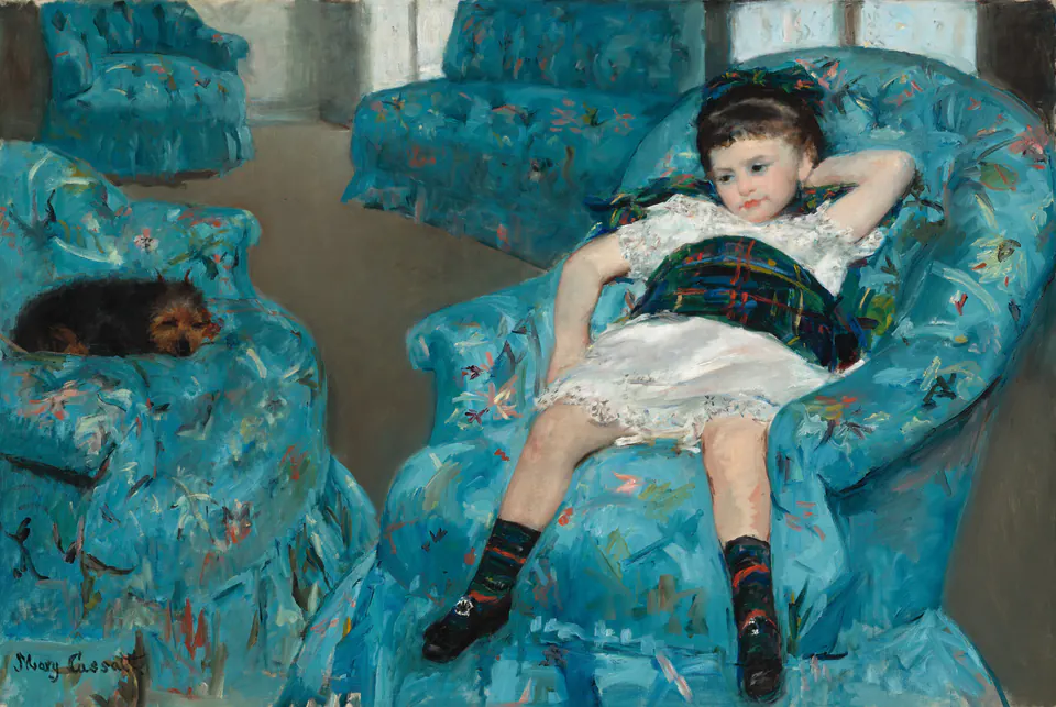 A girl reclining in one of several vivid blue armchairs with a small dog asleep nearby