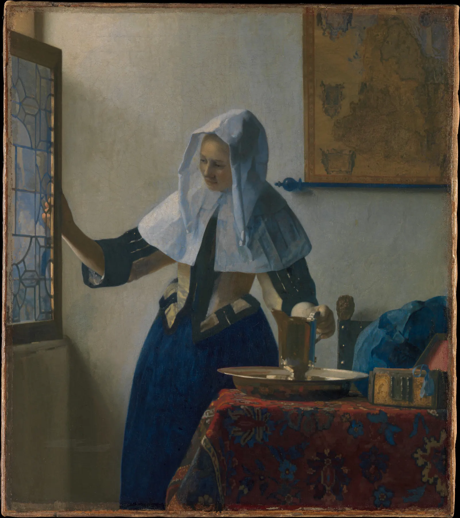 Young Woman with a Water Pitcher by Johannes Vermeer, standing in a sunlit room beside a table and window
