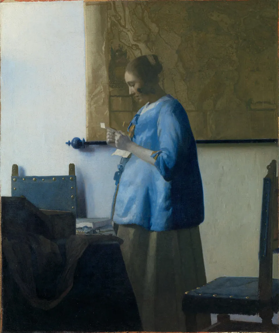 Woman Reading a Letter by Johannes Vermeer, standing in profile before a wall map in a blue jacket