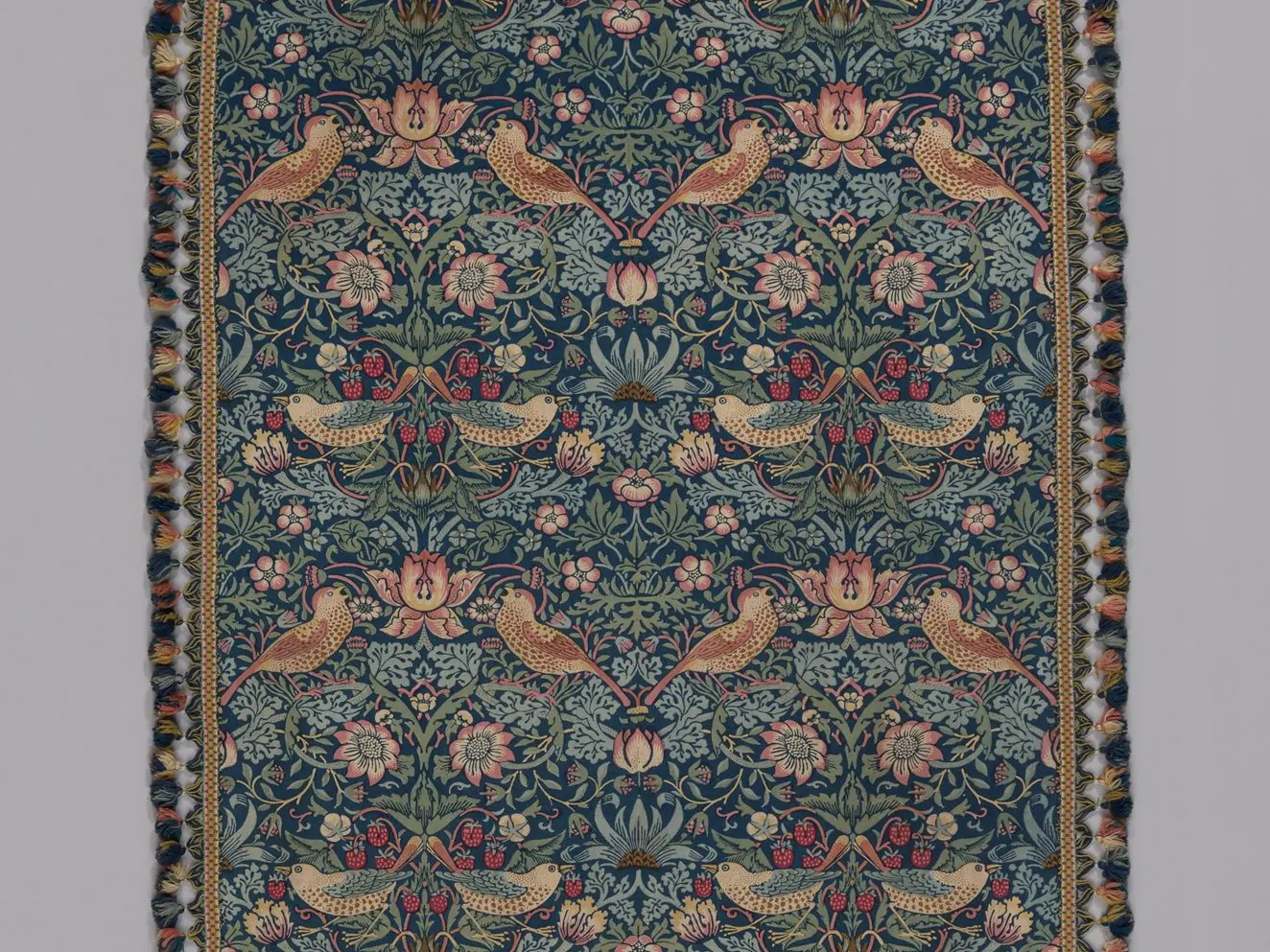 William Morris's Strawberry Thief textile, with repeated birds among flowers and fruit on a dark ground