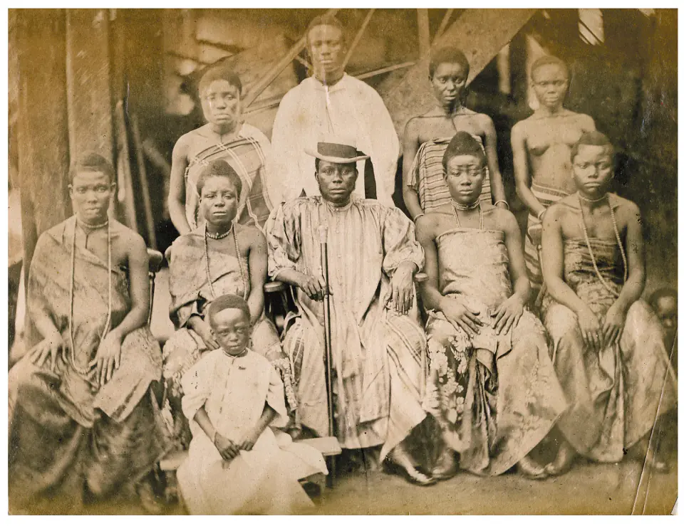 Albümin grup fotoğrafında Şef William Brown şapka ve cübbeyle merkezde oturuyor; dokuz aile üyesi Bonny'deki ahşap yapının önünde, çevresinde iki sıraya diziliyor.
