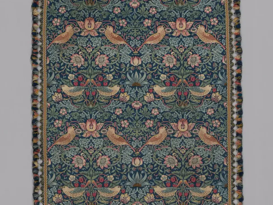 Paired birds, strawberries and curling foliage repeat across a cropped detail of Morris’s Strawberry Thief textile