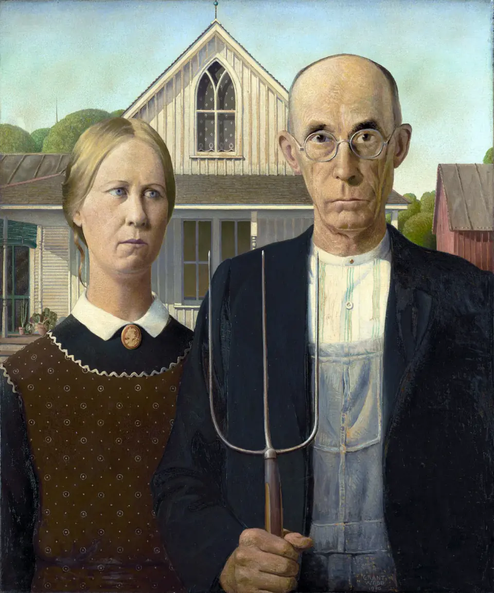 A woman and a man holding a pitchfork stand before a white house with a pointed upstairs window.